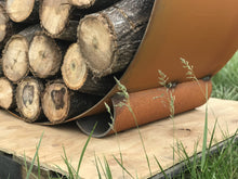 Fire Pit Art Orbit log rack loaded with firewood